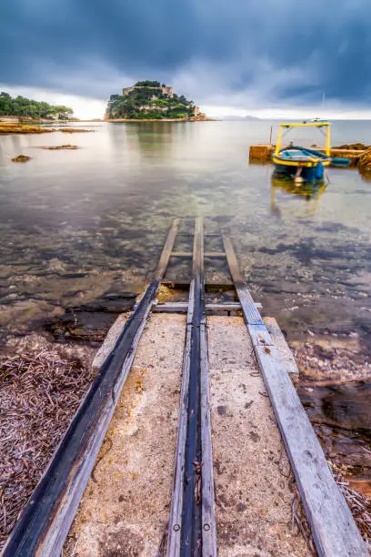 Scenic view of boats launchpad made of wooden rail on concrete pad vanishing to the sea in south of France near Saint Tropez during autumn rain