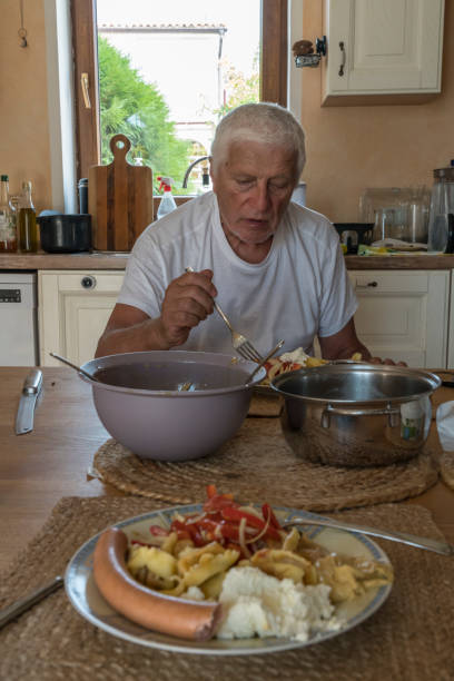 istock Senior men in domestic kitchen eating 1952958709