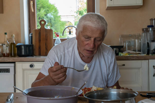 istock Senior men in domestic kitchen eating 1952959182