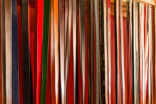 Colored leather belts hanging in a store. High resolution 42Mp studio digital capture taken with SONY A7rII and Zeiss Batis 40mm F2.0 CF lens