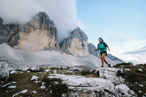 Female runner on top of the Tre Cime di Lavaredo, blazing fast through the scenic route.
