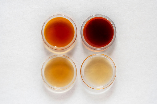 Different classes of maple syrups in different colours in glass dishes
