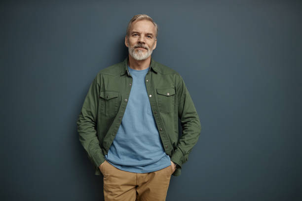 istock Bearded mature man looking at camera against grey 1952992024
