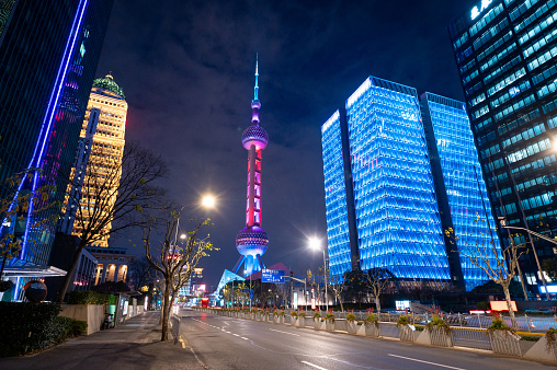 Shanghai downtown streets with the iconic Oriental Pearl Tower stands tall against the cityscape in Lujiazui district . This vibrant night view captures the modern allure of one of China's most iconic landmarks.