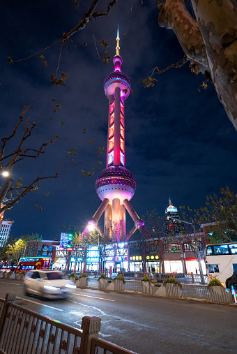 Shanghai downtown streets with the iconic Oriental Pearl Tower stands tall against the cityscape in Lujiazui district . This vibrant night view captures the modern allure of one of China's most iconic landmarks.