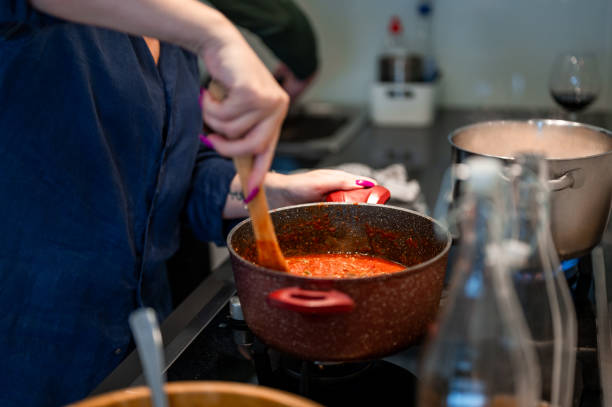 istock Woman cooking a tomato sauce 1952998789