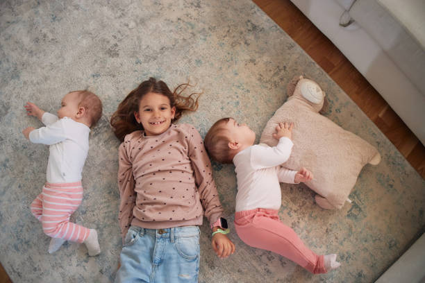 istock Young girl is playing with her twin sisters 1953046936