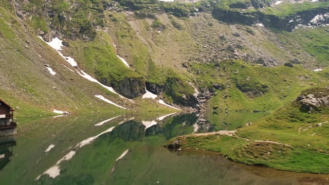 Panning video of old cabin and Balea Lake on transfagarasan mountain road