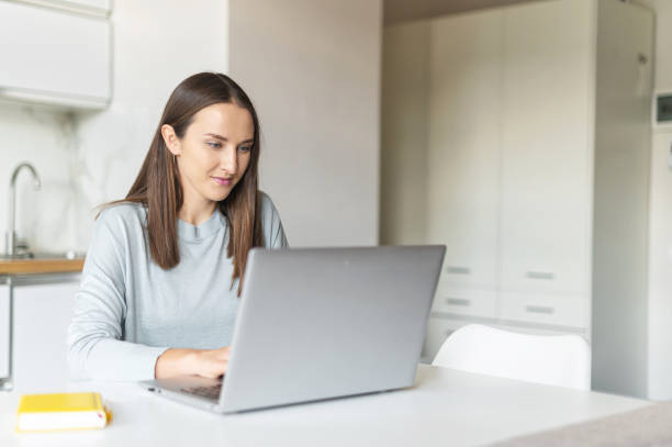 istock Charming young woman using laptop computer for working from home, 1953115581