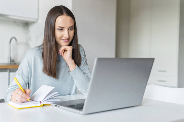 istock Charming young woman using laptop computer for working from home 1953115919