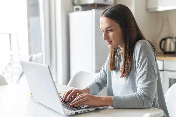 istock Charming young woman using laptop computer for working from home 1953115932