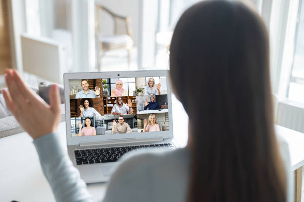 istock Woman using laptop for video conference, back view 1953115946