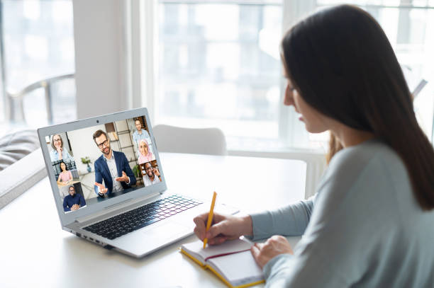 istock Woman using laptop for video conference, back view 1953115951