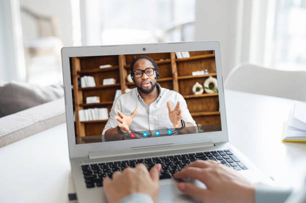 istock Woman using laptop for video conference, back view 1953115955