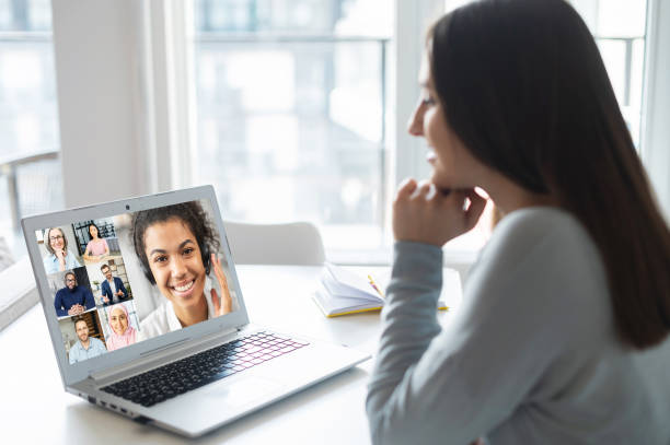 istock Woman using laptop for video conference, back view 1953115956
