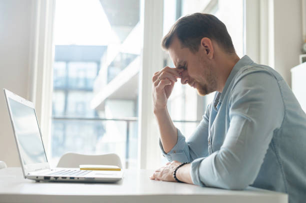 istock Tired young businessman has vision problem after long-time work with a laptop 1953116932