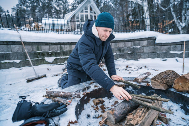 istock Young man starting outdoor fire in winter 1953127040