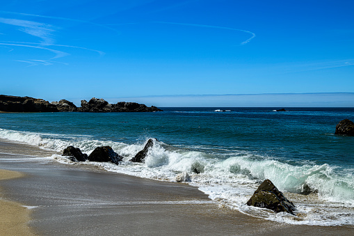 Wide view of waves crashing on shore rocks of Garrapata Beach.\n\nTaken at Garrapata Beach, Big Sur, California, USA