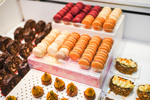 Colorful macarons displayed in rows, assorted flavors for dessert.