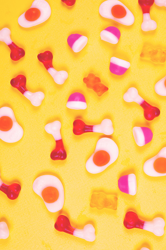 Assorted jelly sweets on yellow background. Pattern.