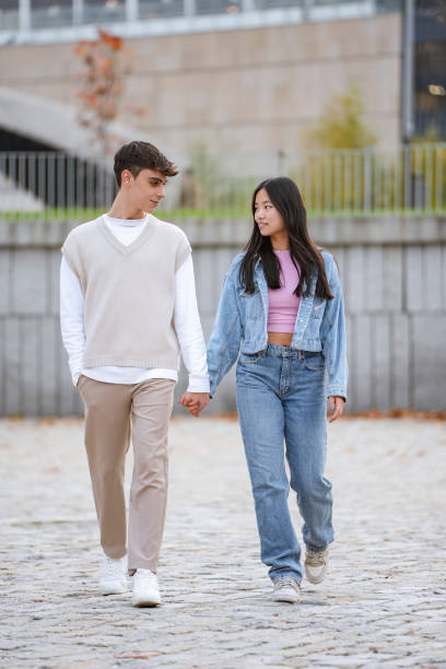 istock Couple holding hands and smiling while enjoying a walk together. 1953163227