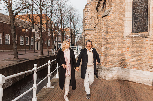Senior diverse couple made up of a beautiful blond woman and handsome asian man on staycation in Delft in the winter