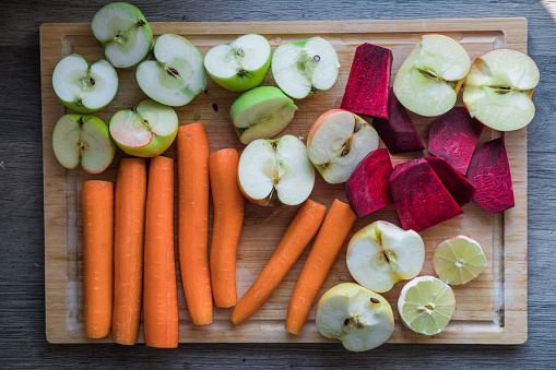 Carrots, apples, beets and lemon cut and prepared for juicing