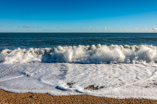 Crashing wave on a beach on a sunny day