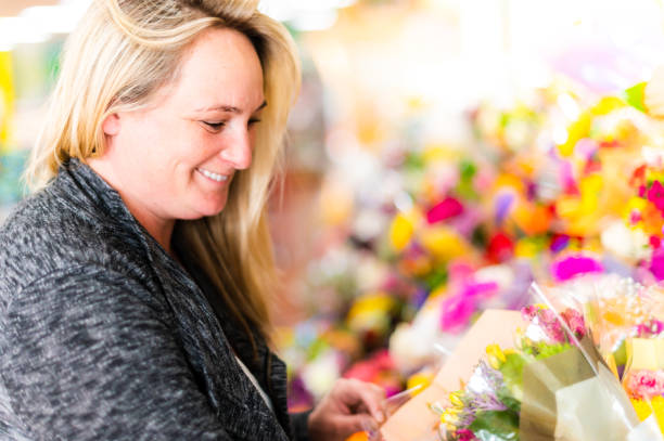 woman shopping for flowers at a grocery, floral or specialty shop - florist supermarket flower bouquet 뉴스 사진 이미지