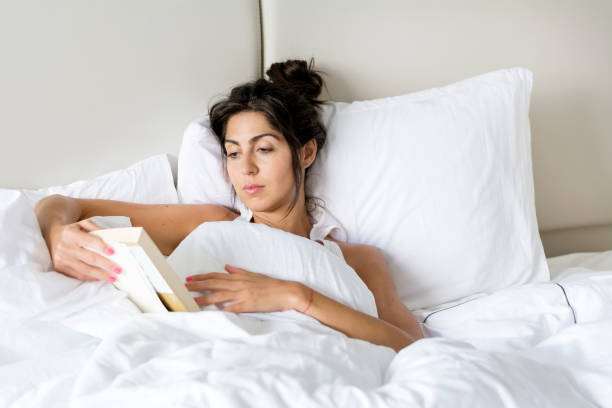 istock Woman  reading book in the bed 1953208023