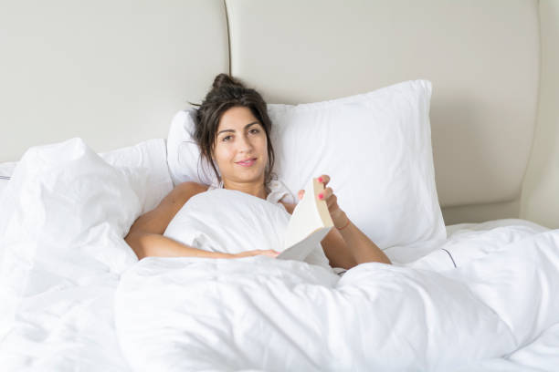 istock Woman  reading book in the bed 1953208030