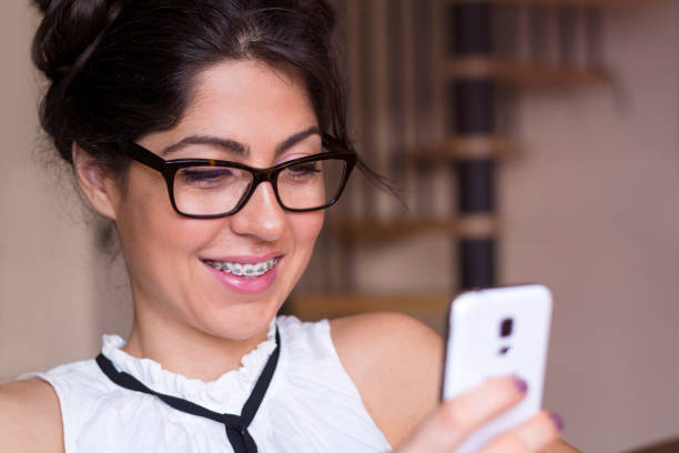 istock Smiling Woman using her phone at home 1953216832