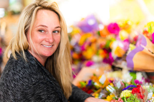 woman shopping for flowers at a grocery, floral or specialty shop - florist supermarket flower bouquet ストックフォトと画像