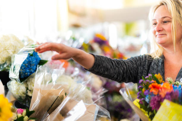 食料品店、花屋、専門店で花を買う女性 - florist supermarket flower bouquet ストックフォトと画像