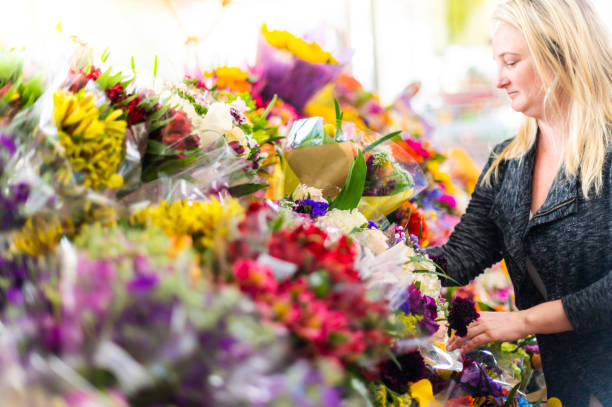 食料品店、花屋、専門店で花を買う女性 - florist supermarket flower bouquet ストックフォトと画像