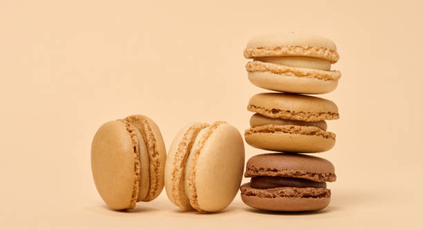 istock Chocolate macarons on a beige background, a stack of dessert 1953272475