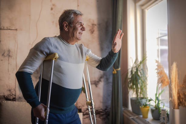 istock An elderly man walks with the help of crutches 1953274845