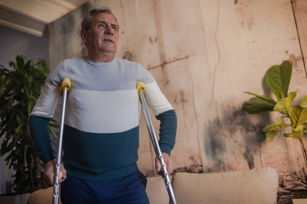 istock An elderly man walks with the help of crutches 1953275399