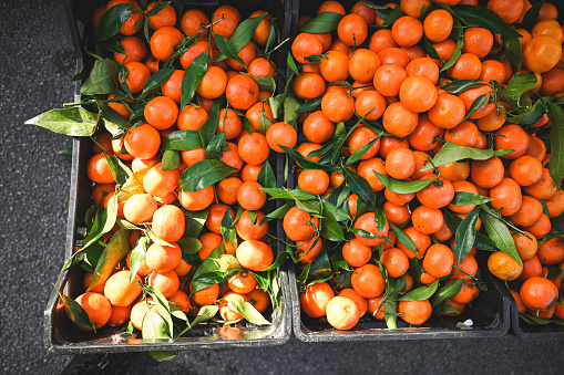 A lot of tangerines a baskets on a street market.