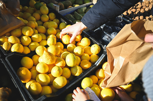 choosing ripe fruits in an outdoors farmer's market.