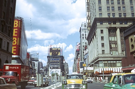 New York City, NY, USA, 1964. Street scene with vehicles, buildings, pedestrians and advertising signs in Times Square in downtown Manhattan.