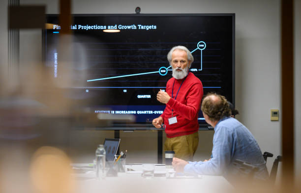 istock Senior man presenting report in meeting room 1953319659