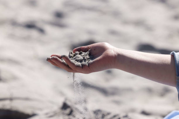 istock Child Holding Sand in Their Hand 1953356640