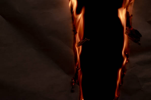 istock burning paper, glowing edge of paper 1953359899
