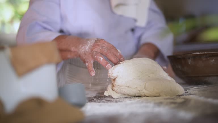 Hands, person and dough with pastry on kitchen table for bread, kneading or handmade cake for preparation. Chef, wheat and baking or cooking process on counter in restaurant, bakery or culinary cook