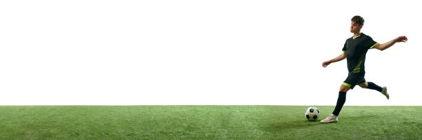 istock Young guy, soccer player in motion with ball training isolated over white background with grass flooring 1953387601