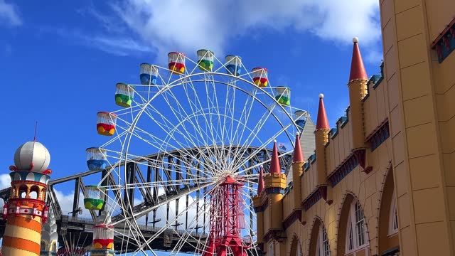 colourful Ferris wheel in Sydney amusement Theme Park with Sydney harbour Bridge in the background NSW Australia