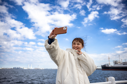 Woman taking selfie pictures at habor
