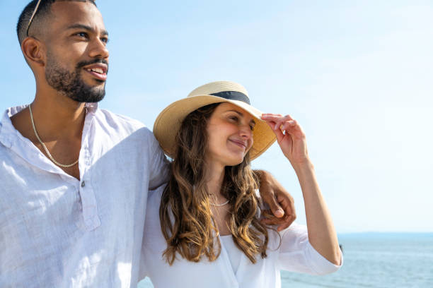 istock Smiling couple walking on beach 1953584670