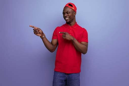 business concept. young delivery worker american man in red t-shirt and baseball cap with print mockup.